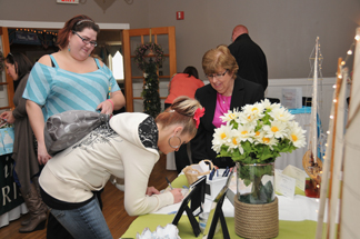 Bride signing name at wedding expo.